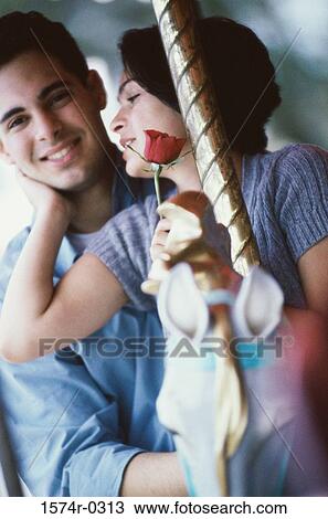 Young couple riding on a carousel View Large Photo Image Stock Image - Young couple riding on a carousel. Fotosearch