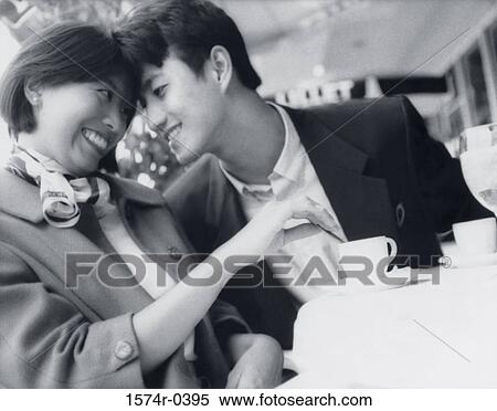 Young couple sitting at a table View Large Photo Image Stock Photography - Young couple sitting at a table. Fotosearch
