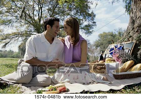 Young couple sitting together at a picnic View Large Photo Image Stock Image - Young couple sitting together at a picnic. Fotosearch