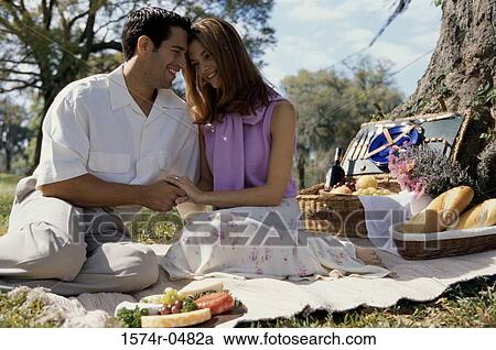 Stock Image - Young couple sitting together at a picnic. Fotosearch