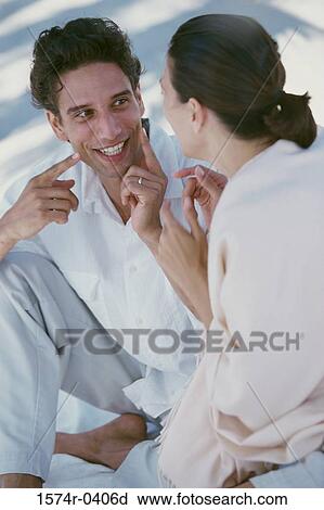 Young couple sitting together at the beach View Large Photo Image Stock Image - Young couple sitting together at the beach. Fotosearch