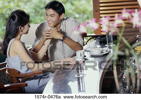 Stock Image - Young couple sitting together in a restaurant. Fotosearch