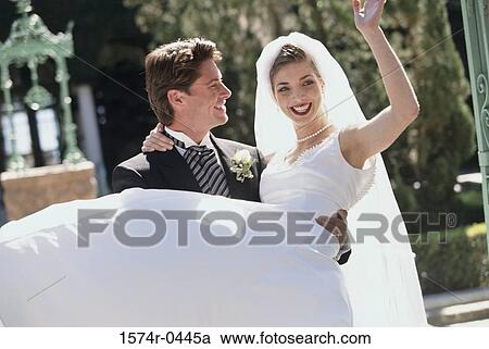 Young man carrying a young woman at their wedding View Large Photo Image Stock Image - Young man carrying a young woman at their wedding. Fotosearch