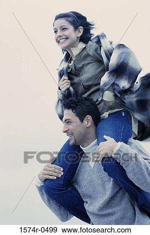 Stock Photo - Young man carrying a young woman on his shoulders. Fotosearch