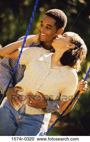 Young man holding a young woman on a swing View Large Photo Image Stock Image - Young man holding a young woman on a swing. Fotosearch