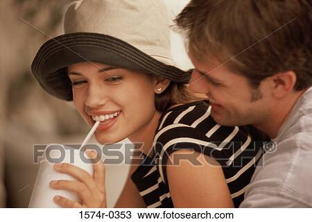 Young woman drinking from a cup with a young man holding her from behind View Large Photo Image Stock Image - Young woman drinking from a cup with a young man holding her from behind. Fotosearch
