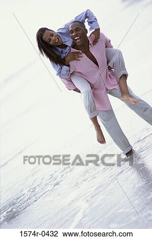 Young woman riding piggyback on a young man View Large Photo Image Stock Image - Young woman riding piggyback on a young man. Fotosearch