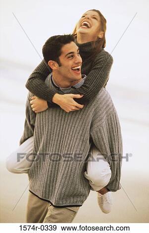 Young woman riding piggyback on a young man View Large Photo Image Stock Photo - Young woman riding piggyback on a young man. Fotosearch