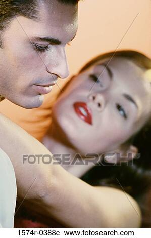 Stock Image - Young woman with her arms around a young man. Fotosearch