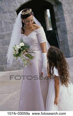Bride holding a bouquet of flowers talking to a flower girl View Large Photo Image Stock Image - Bride holding a bouquet of flowers talking to a flower girl. Fotosearch