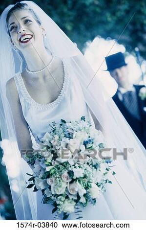 Bride holding a bouquet of flowers smiling View Large Photo Image Stock Image - Bride holding a bouquet of flowers smiling. Fotosearch