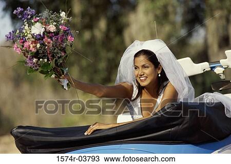 Bride preparing to toss a bouquet of flowers from a convertible car View Large Photo Image Stock Image - Bride preparing to toss a bouquet of flowers from a convertible car. Fotosearch