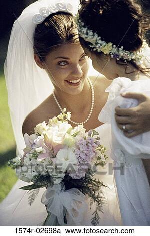 Stock Image - Close-up of a bride smiling at a flower girl. Fotosearch