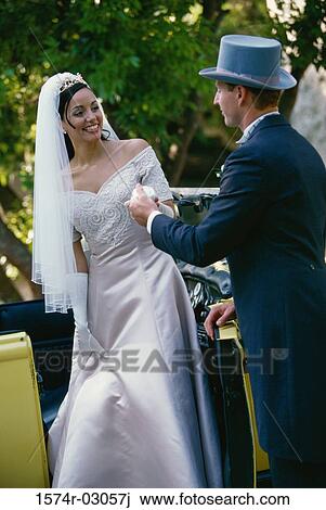 Stock Image - Groom holding his bride's hand. Fotosearch