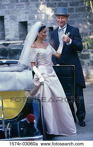Stock Image - Groom holding his bride's hand. Fotosearch