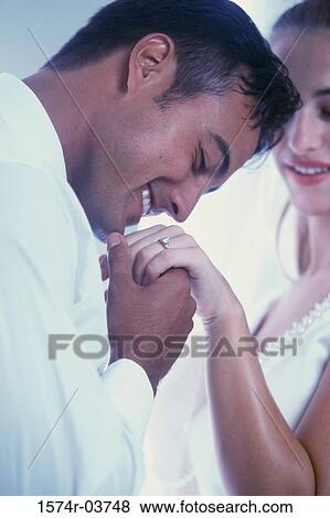 Stock Photo - Groom kissing his bride's hand. Fotosearch