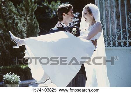 Groom lifting his bride View Large Photo Image Stock Photography - Groom lifting his bride. Fotosearch