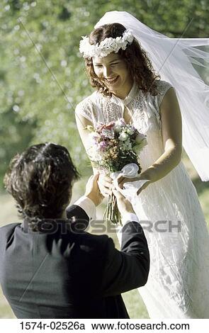 High angle view of a groom giving a bouquet of flowers to his bride View Large Photo Image Stock Image - High angle view of a groom giving a bouquet of flowers to his bride. Fotosearch