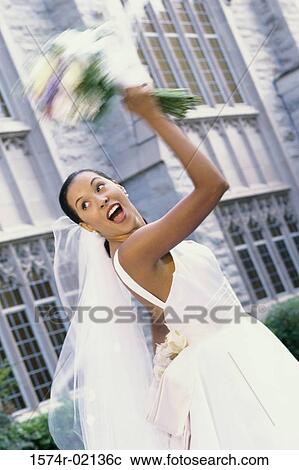 Low angle view of a newlywed young woman tossing the bouquet View Large Photo Image Stock Image - Low angle view of a newlywed young woman tossing the bouquet. Fotosearch