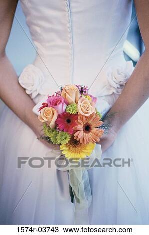 Mid section view of a bride hiding a bouquet of flowers View Large Photo Image Stock Image - Mid section view of a bride hiding a bouquet of flowers. Fotosearch