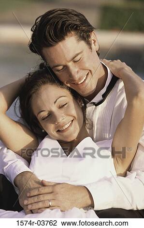 Stock Image - Newlywed couple embracing each other. Fotosearch