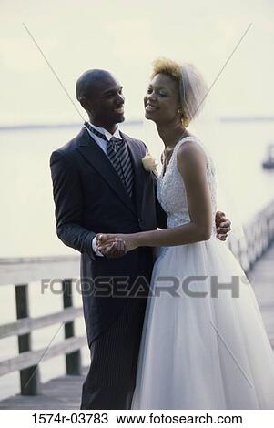 Stock Image - Newlywed couple embracing on a pier. Fotosearch