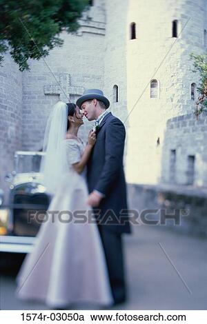Newlywed couple kissing each other in front of an antique car View Large Photo Image Stock Image - Newlywed couple kissing each other in front of an antique car. Fotosearch