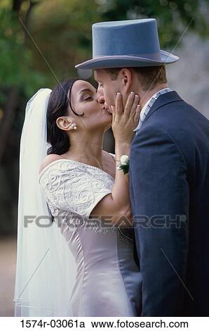 Newlywed couple kissing each other View Large Photo Image Stock Image - Newlywed couple kissing each other. Fotosearch