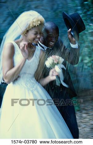 Newlywed couple running in rain shower View Large Photo Image Stock Image - Newlywed couple running in rain shower. Fotosearch