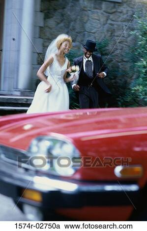 Newlywed couple running towards a car View Large Photo Image Stock Image - Newlywed couple running towards a car. Fotosearch
