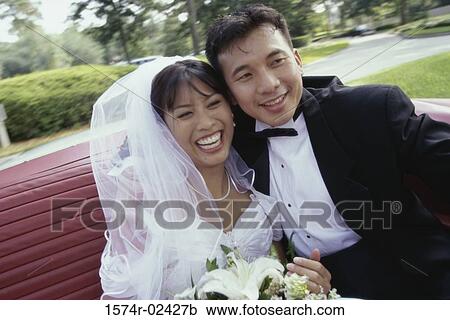 Newlywed couple sitting in a convertible car View Large Photo Image Stock Image - Newlywed couple sitting in a convertible car. Fotosearch