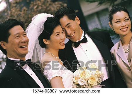 Stock Photo - Newlywed couple smiling with their parents. Fotosearch