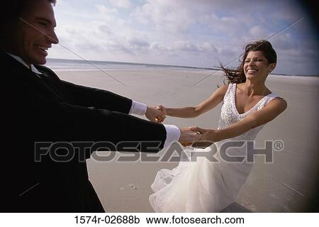 Newlywed couple spinning each other on the beach View Large Photo Image Stock Image - Newlywed couple spinning each other on the beach. Fotosearch