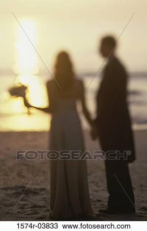 Newlywed couple standing on the beach View Large Photo Image Stock Image - Newlywed couple standing on the beach. Fotosearch