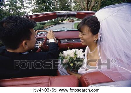 Newlywed couple talking to each other in a convertible car View Large Photo Image Stock Photography - Newlywed couple talking to each other in a convertible car. Fotosearch