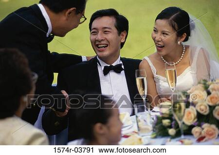 Stock Image - Newlywed couple talking to their parents. Fotosearch