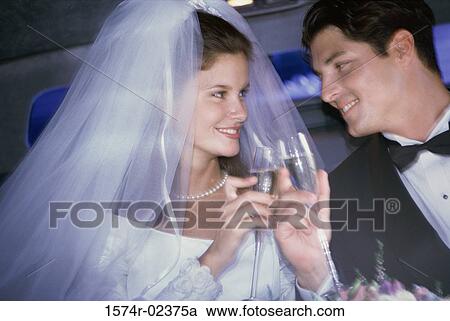 Newlywed couple toasting with champagne glasses in a car View Large Photo Image Stock Image - Newlywed couple toasting with champagne glasses in a car. Fotosearch