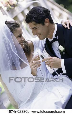 Newlywed couple toasting with glasses of champagne View Large Photo Image Stock Image - Newlywed couple toasting with glasses of champagne. Fotosearch