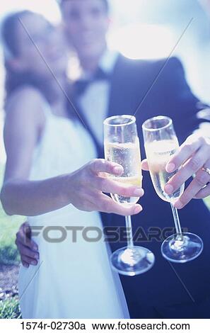Stock Image - Newlywed couple toasting with glasses of champagne. Fotosearch