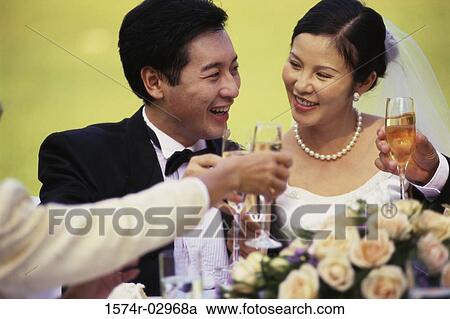 Newlywed couple toasting with glasses of champagne View Large Photo Image Stock Image - Newlywed couple toasting with glasses of champagne. Fotosearch