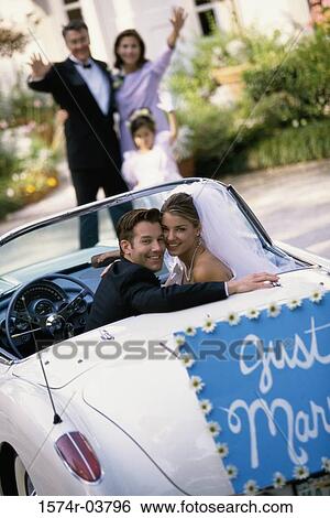 Portrait of a bride and her groom sitting in a convertible car View Large Photo Image Stock Photograph - Portrait of a bride and her groom sitting in a convertible car. Fotosearch