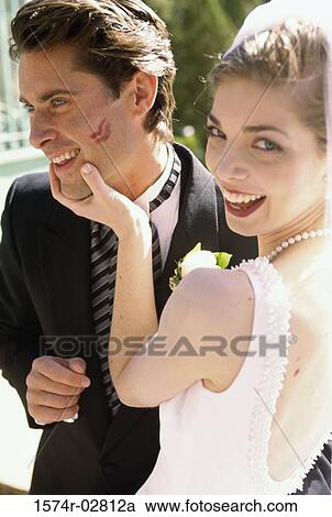 Stock Image - Portrait of a bride holding her groom's face. Fotosearch
