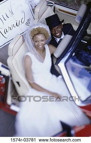 Portrait of a newlywed couple sitting in a convertible car View Large Photo Image Stock Image - Portrait of a newlywed couple sitting in a convertible car. Fotosearch