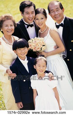 Portrait of a newlywed couple standing with their parents View Large Photo Image Stock Image - Portrait of a newlywed couple standing with their parents. Fotosearch