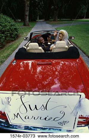Portrait of a newlywed couple waving from a convertible car View Large Photo Image Stock Image - Portrait of a newlywed couple waving from a convertible car. Fotosearch