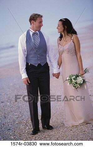 Young couple standing together on the beach View Large Photo Image Stock Image - Young couple standing together on the beach. Fotosearch