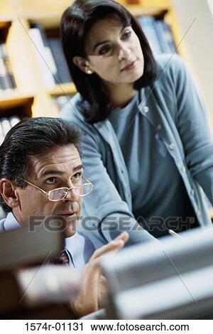 Stock Image - Businessman and a businesswoman in an office. Fotosearch