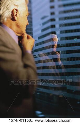 Businessman looking through a window View Large Photo Image Stock Image - Businessman looking through a window. Fotosearch