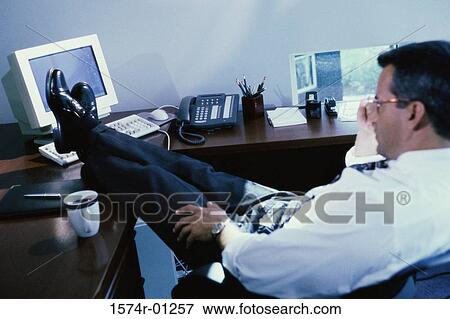 Stock Photo - Businessman reclining in his seat with feet up on the table. Fotosearch