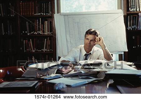 Businessman sitting alone in a conference room View Large Photo Image Picture - Businessman sitting alone in a conference room. Fotosearch